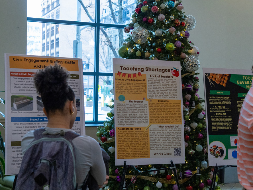 Students discuss their research projects at the Fall Forum in December 2025. 