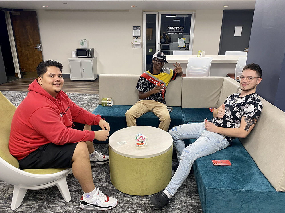 Three students play Uno at the board games station during the Pioneer Pause.