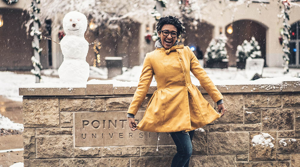 A Point Park University student with a snowman in Village Park. Photo | Nick Koehler