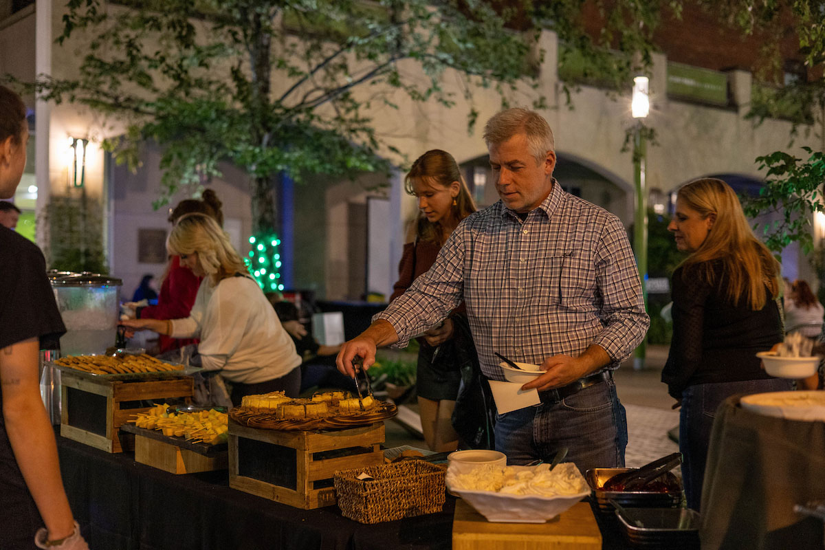 A family member gets food from a buffet. 