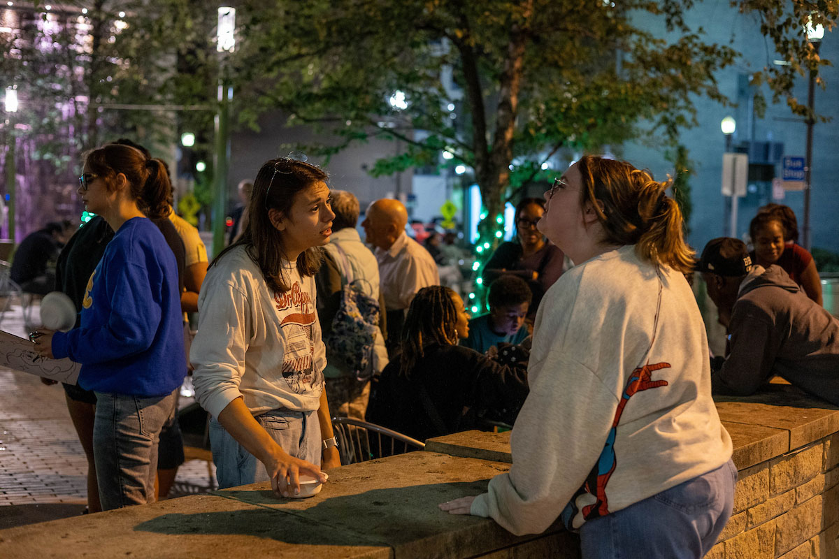 Students talk in Village Park in the evening. 