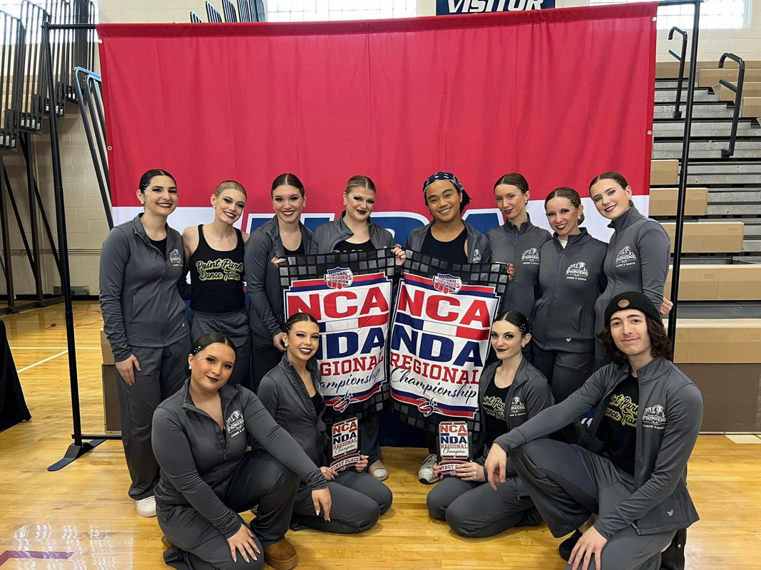 The team poses in a gym at a competition.