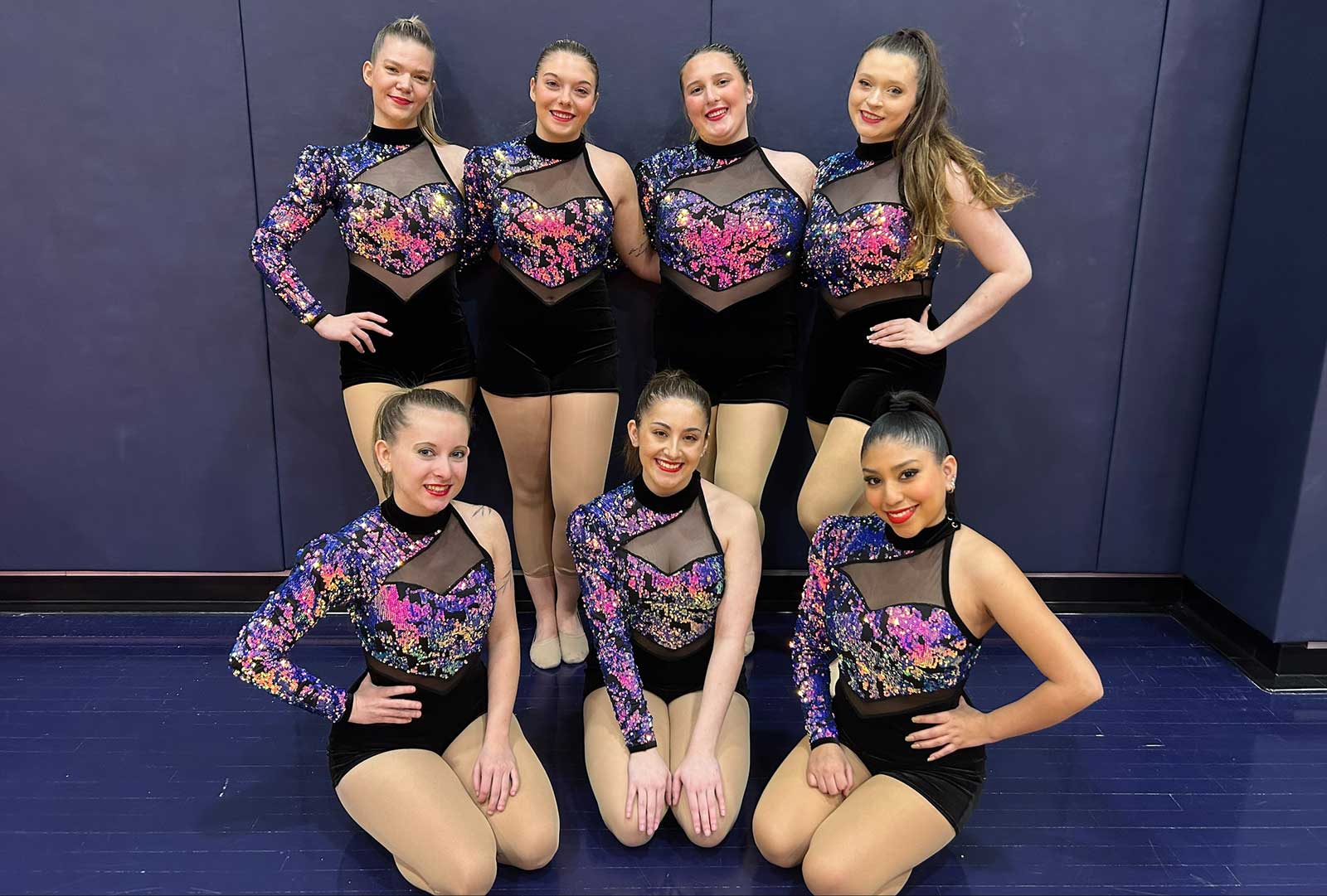 Members of the dance team pose for a photo in two rows.