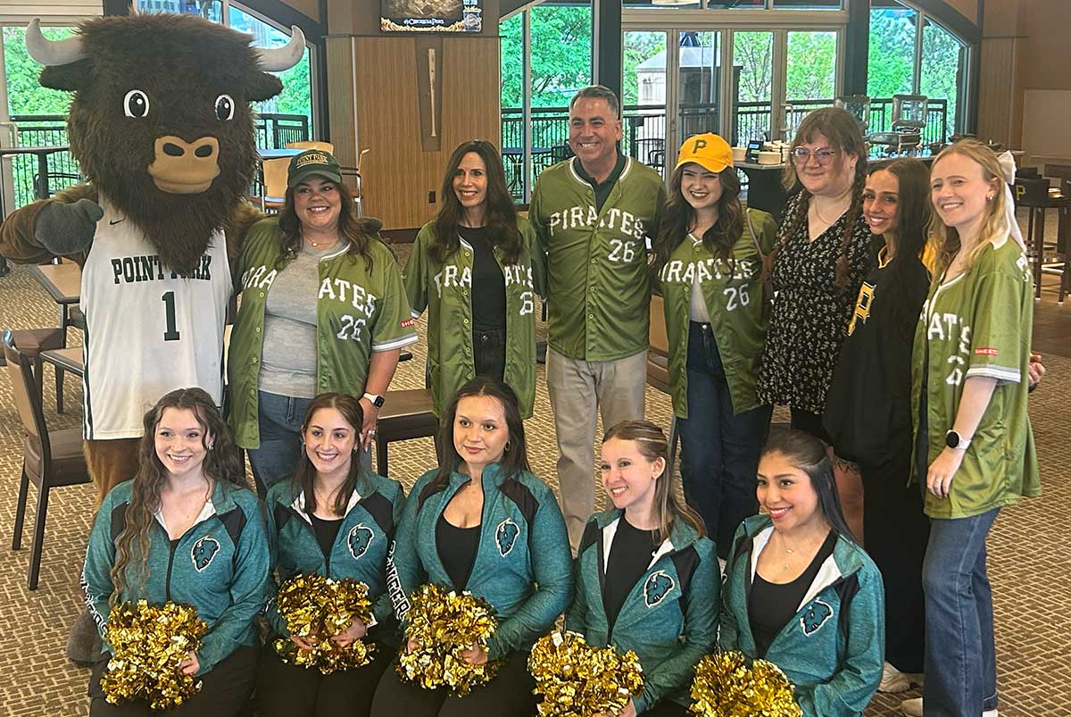 Members of the cheer team pose with people from the alumni and advancement office.