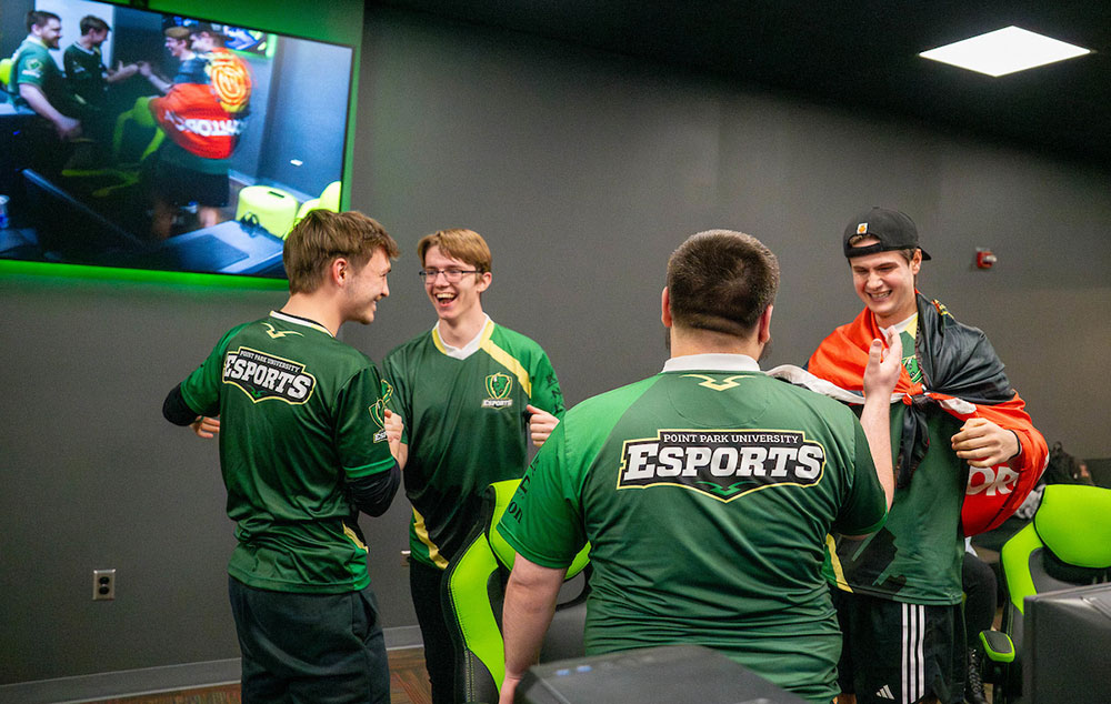 Members of the esports team congratulate one another on a win.