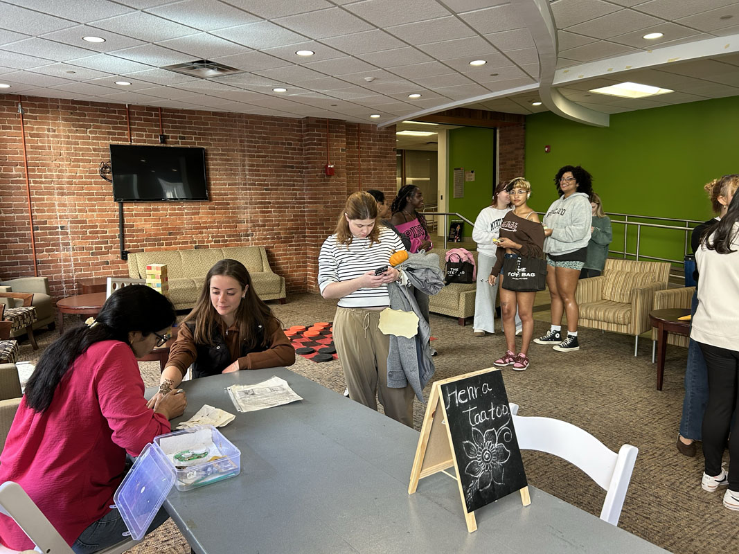 Students wait for their turn to get a henna tattoo.