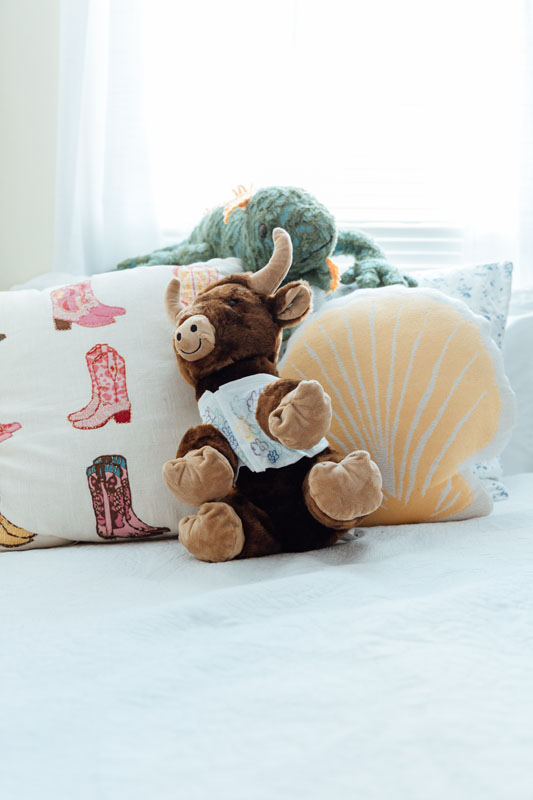 A stuffed bison on a bed.