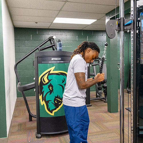A student works out on a machine.
