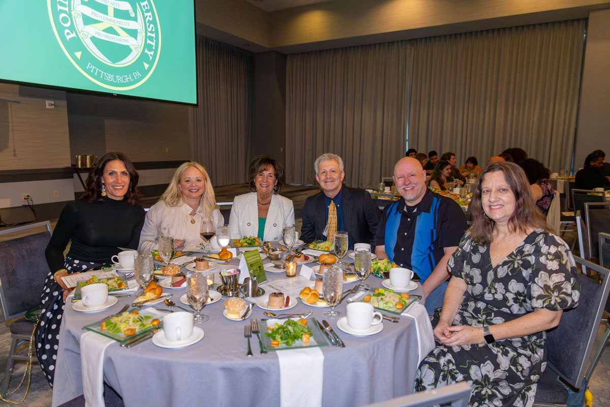 Faculty and staff sit around a dinner table.