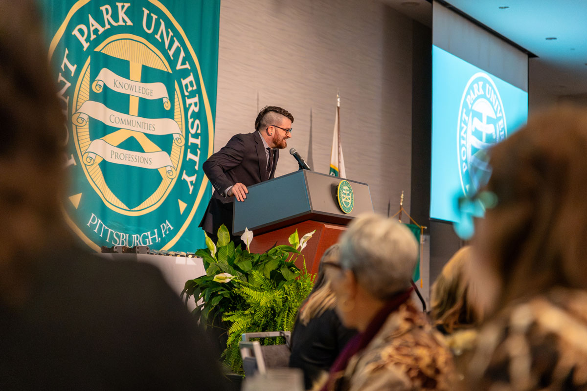 Angelo Gargaro speaks at a podium.