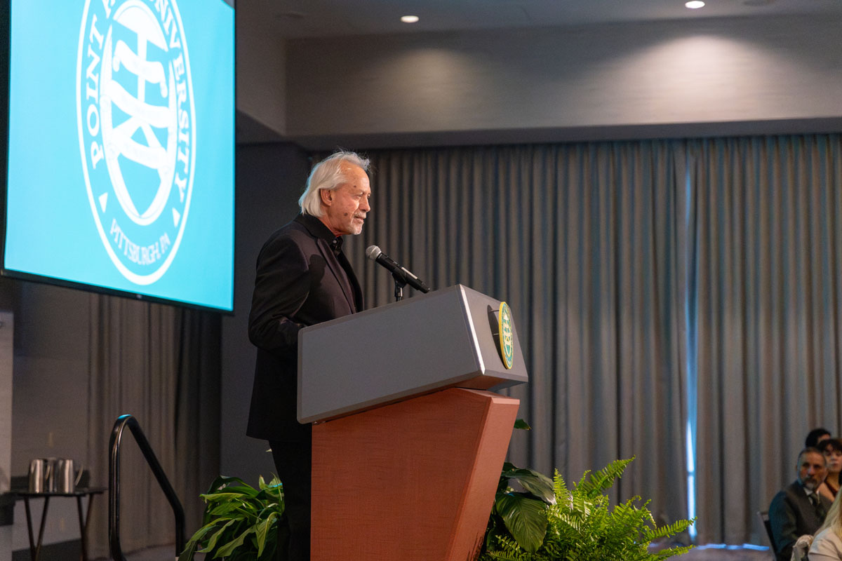 Ed Travasari speaks from a podium. 