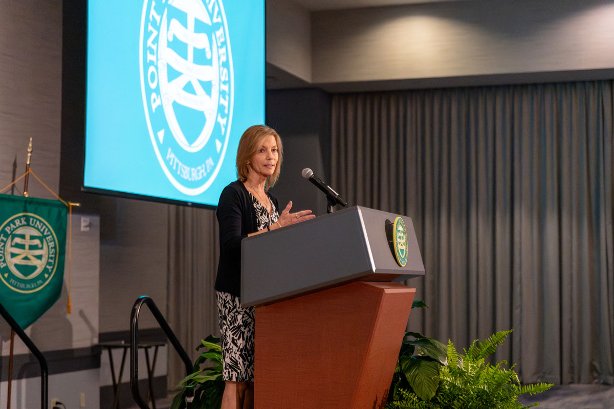 Stephanie Schmader speaks from a podium.